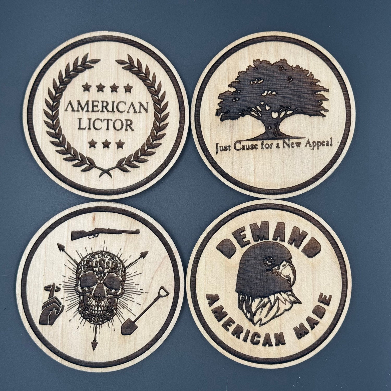 Four circular wooden coasters with engraved designs of American Lictors best selling designs