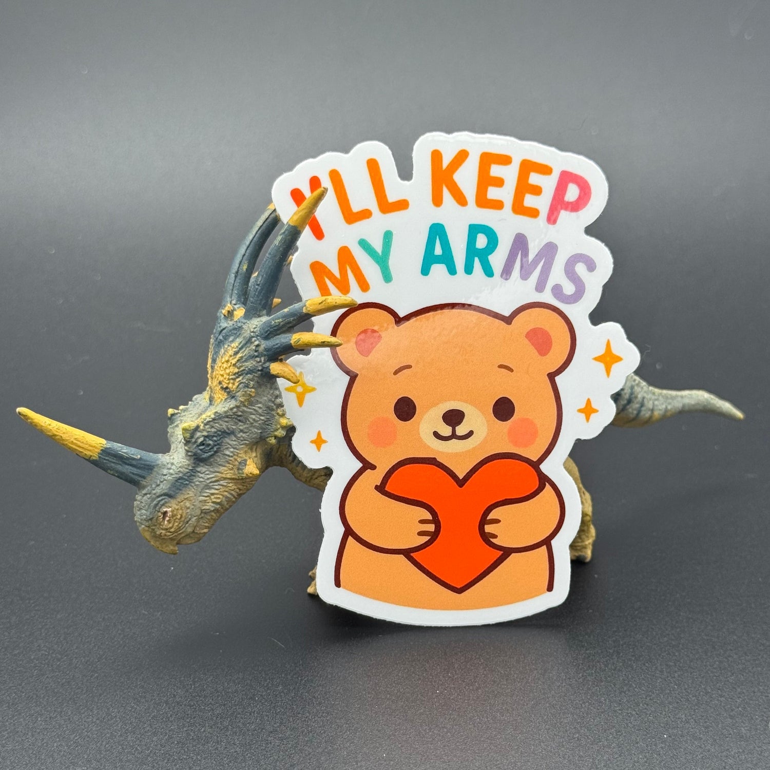 Sticker of a Brown Cartoon bear holding a heart saying