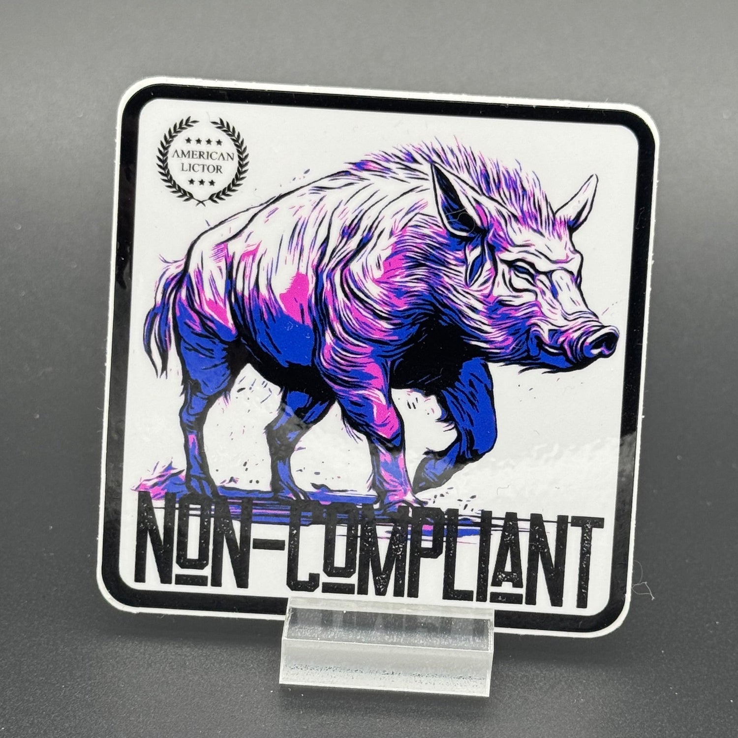 Black, purple, blue and white sticker of a boar with the text 'Non-Compliant'