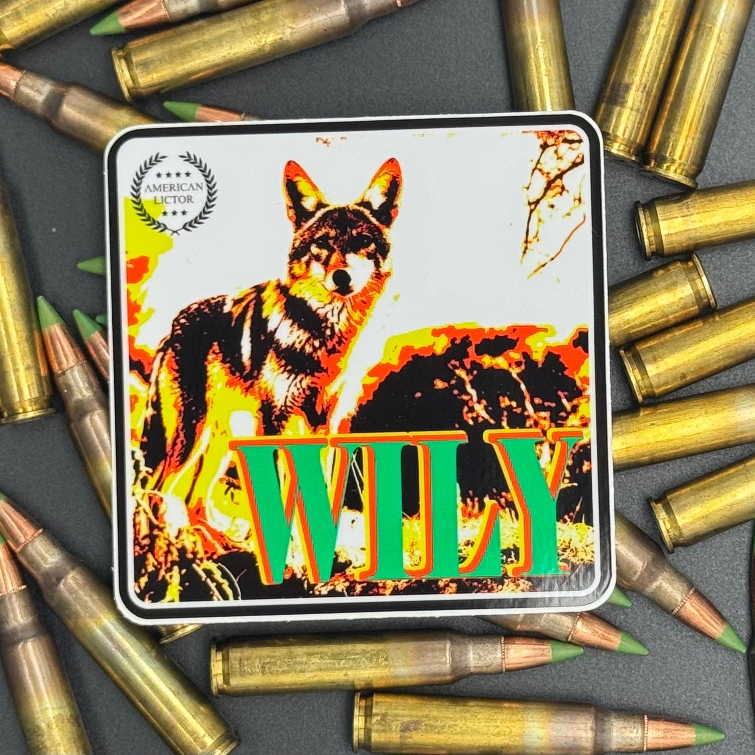Multicolor sticker of a coyote with the text 'Wily' on a bed of ammo