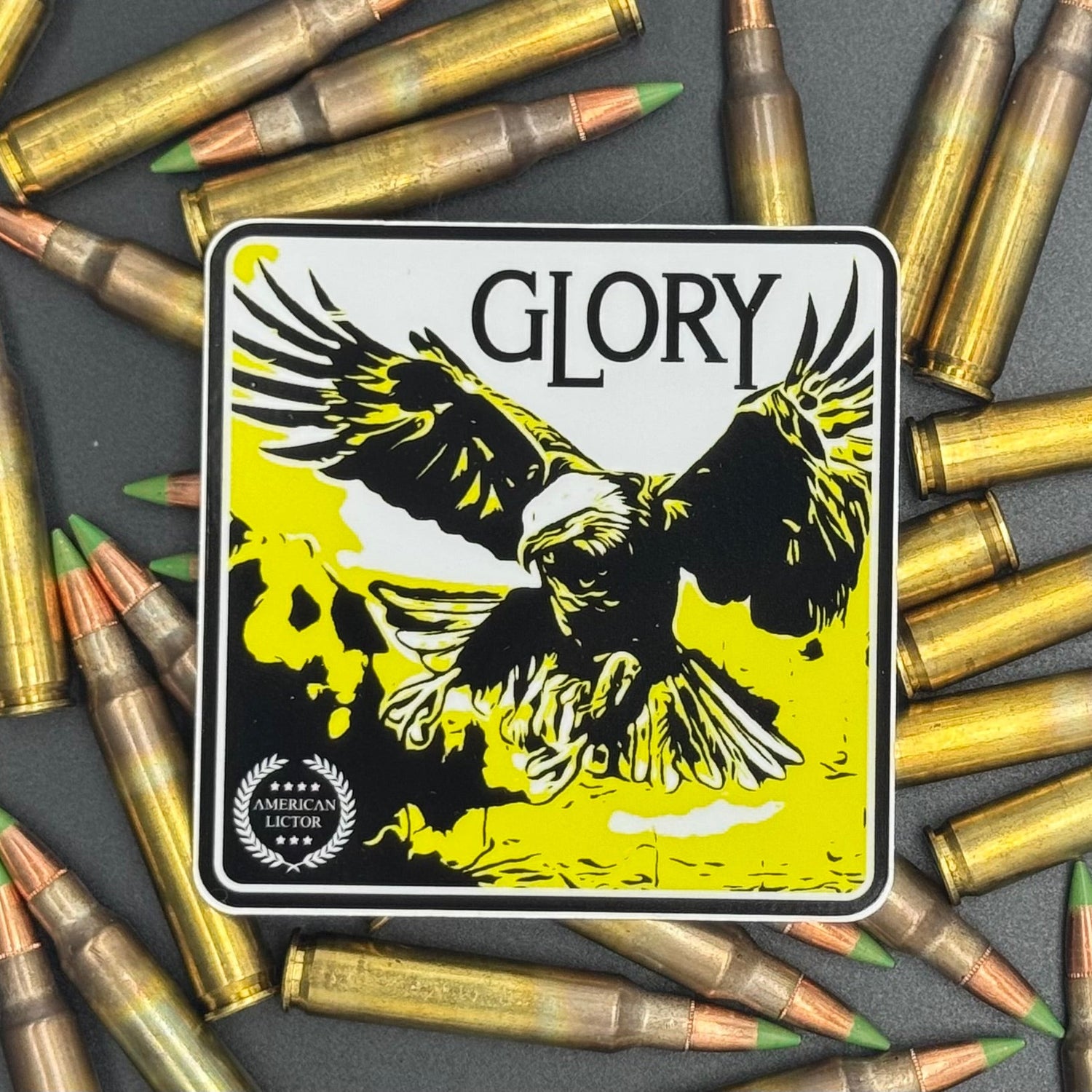 Black, yellow and white sticker of an eagle with the text 'Glory' on a bed of ammo
