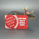 A red metal giftcard with the American Lictor Logo and Slogan " Everything Made in America. Always." posed with a dinosaur