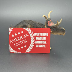 A red metal giftcard with the American Lictor Logo and Slogan " Everything Made in America. Always." posed with a dinosaur