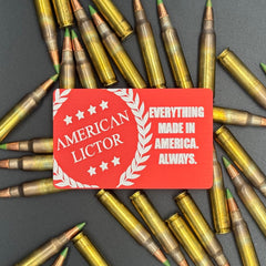 A red metal giftcard with the American Lictor Logo and Slogan " Everything Made in America. Always." on a bed of ammo
