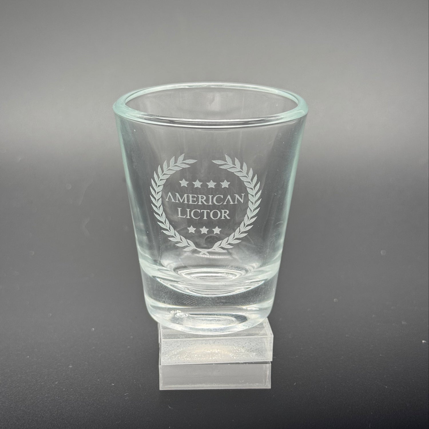 A Shot glass with the American Lictor Logo