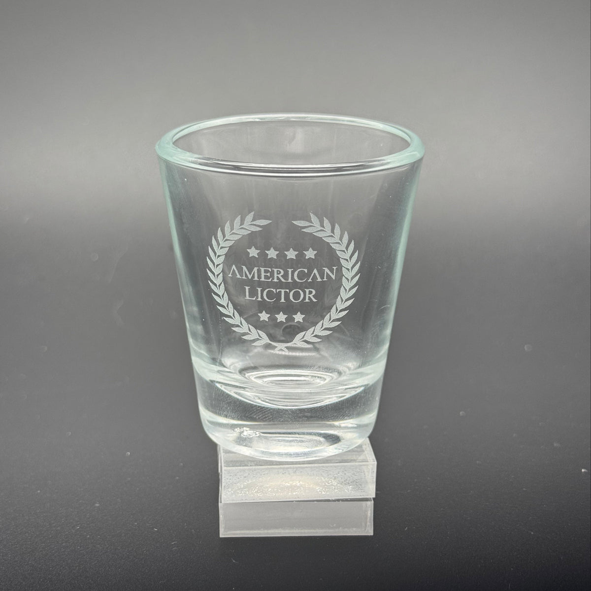 A Shot glass with the American Lictor Logo
