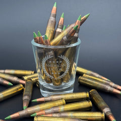 A Shot glass with the American Lictor Logo filled with ammo
