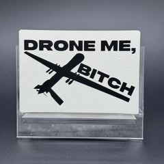 A white leatherette patch of a reaper drone and the text 'Drone Me, Bitch'