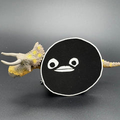 A leatherette patch of goofy cartoon character head wearing a ski mask posed with a dinosaur