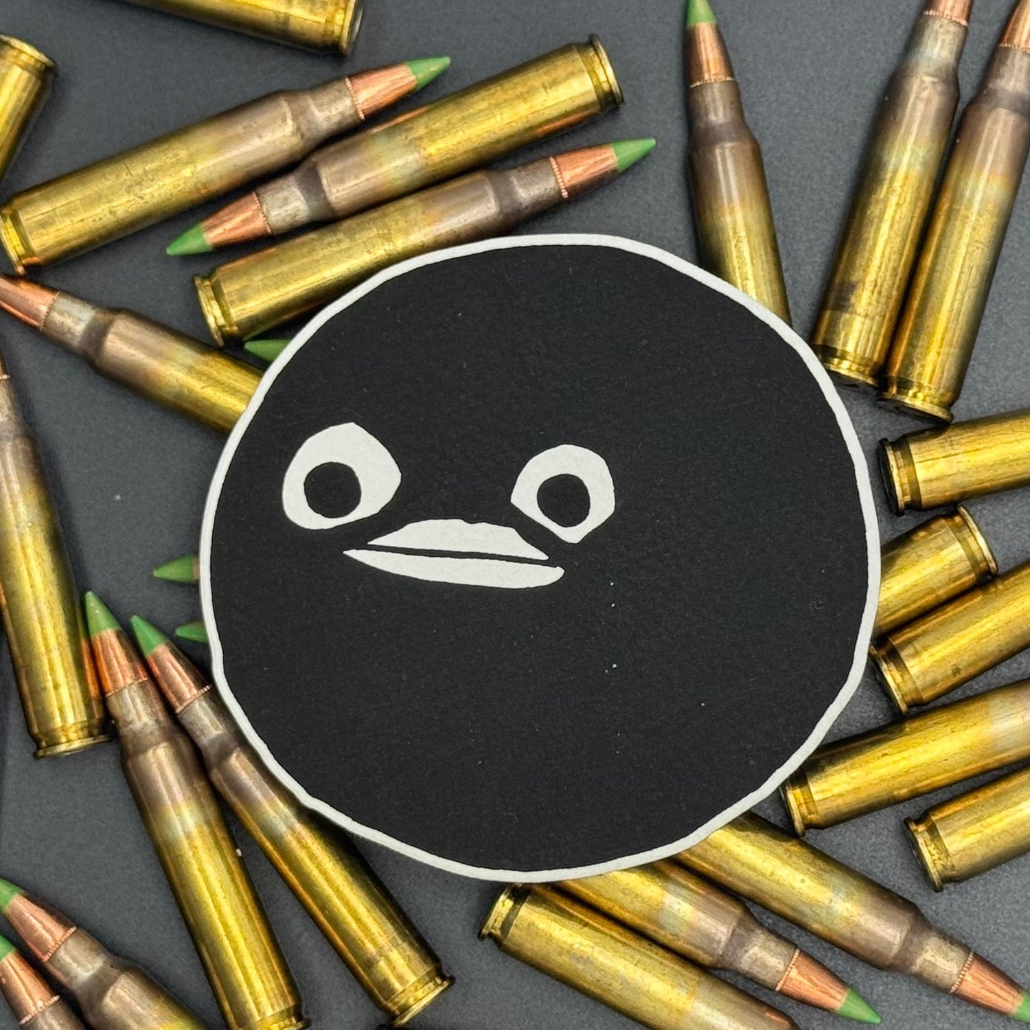 A leatherette patch of goofy cartoon character head wearing a ski mask on a bed of ammo