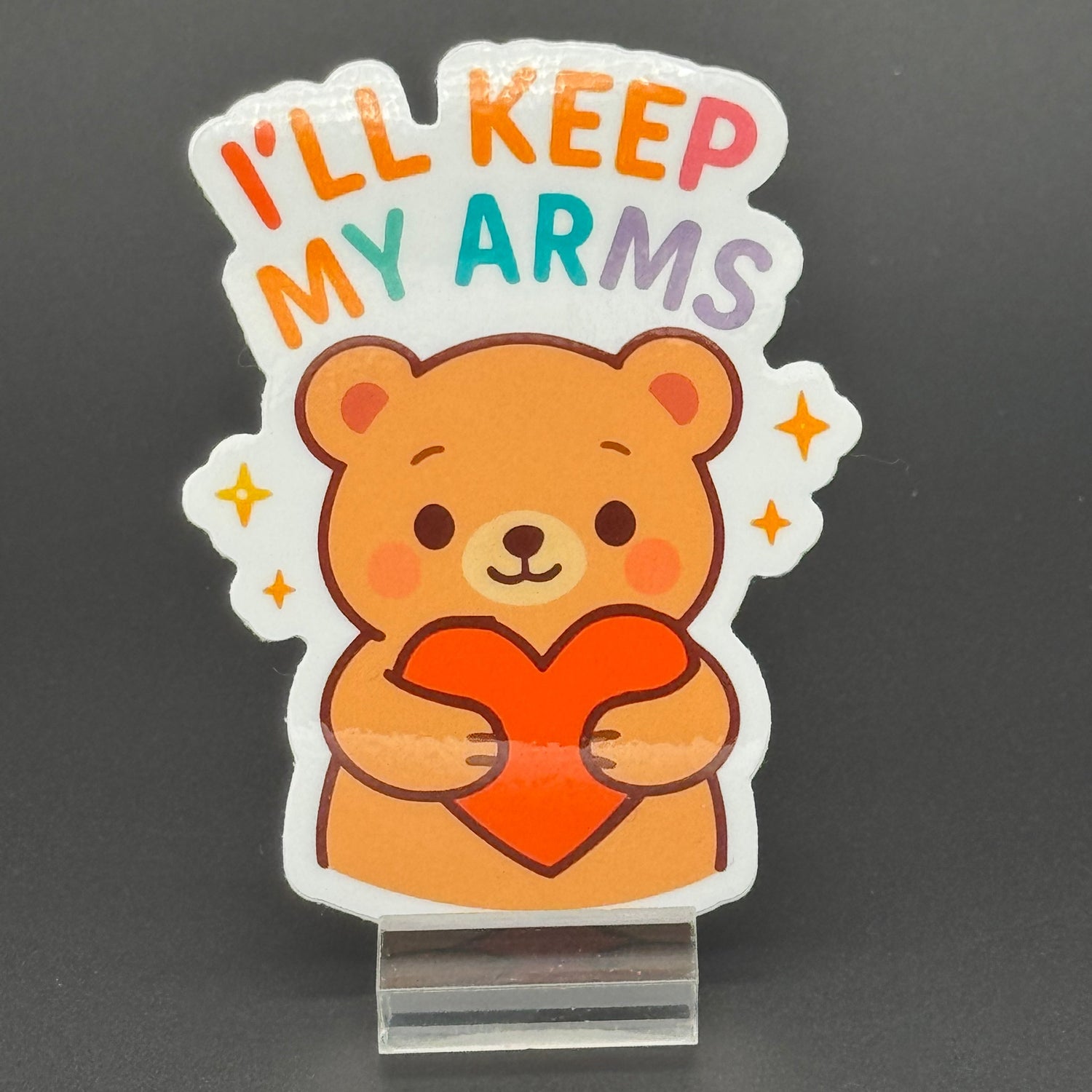Sticker of a Brown Cartoon bear holding a heart saying 