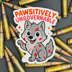 Sticker of a cute wolf covered in blood saying "Pawsitively ungovernable" on a bed of ammo