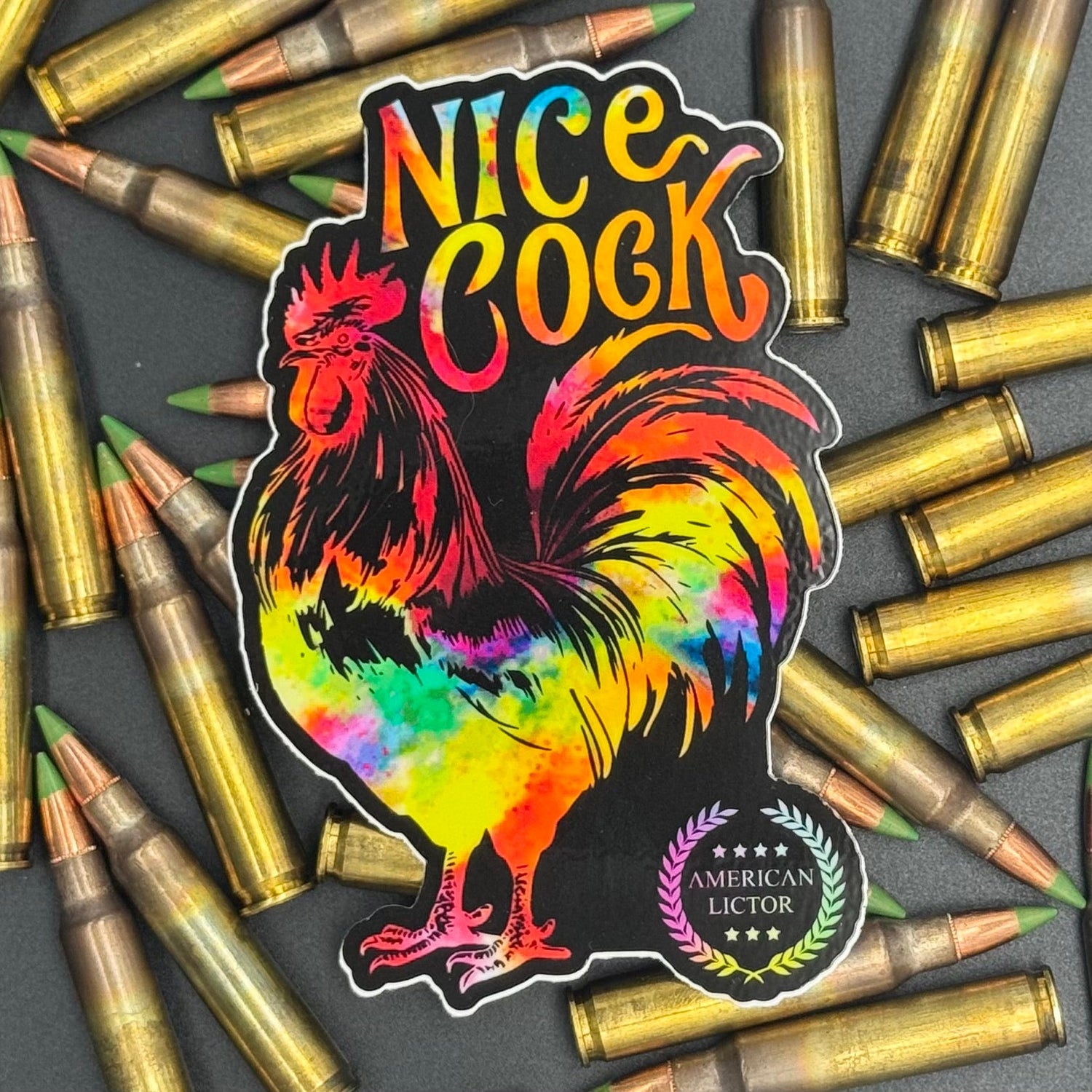 Sticker of a chromatic rooster on a black background with the text 'Nice Cock' on a bed of ammo