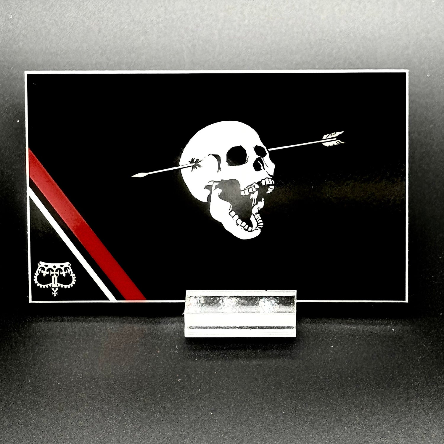 Sticker of a modern pirate flag with a skull with open mouth and arrow through the head and an upside down crown