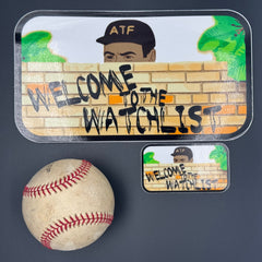 A small and large Sticker of an ATF agent peeking over a wall with the text 'Welcome to the Watchlist' pictured with a baseball for scale