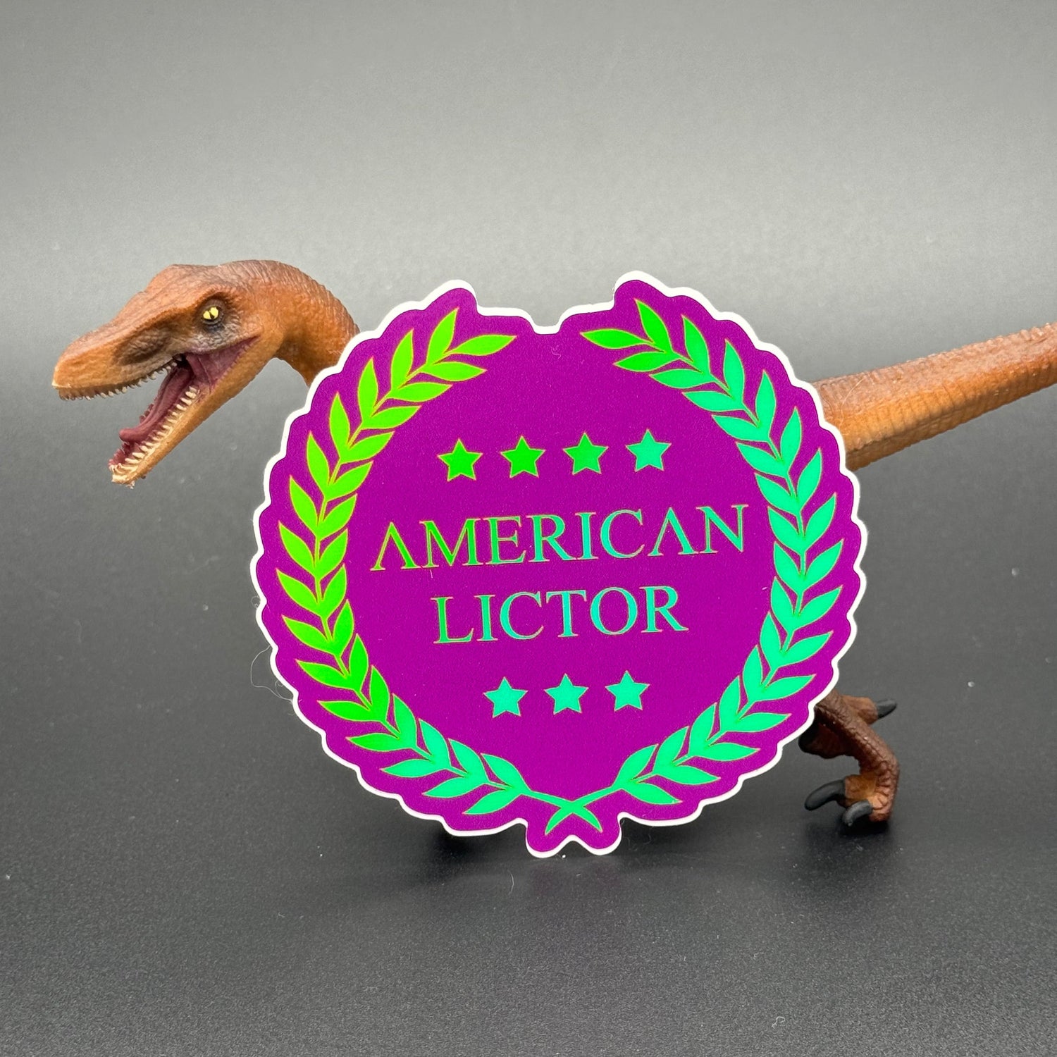 Sticker of the American Lictor Logo in Purple with green chromatic coloring posing with a dinosaur