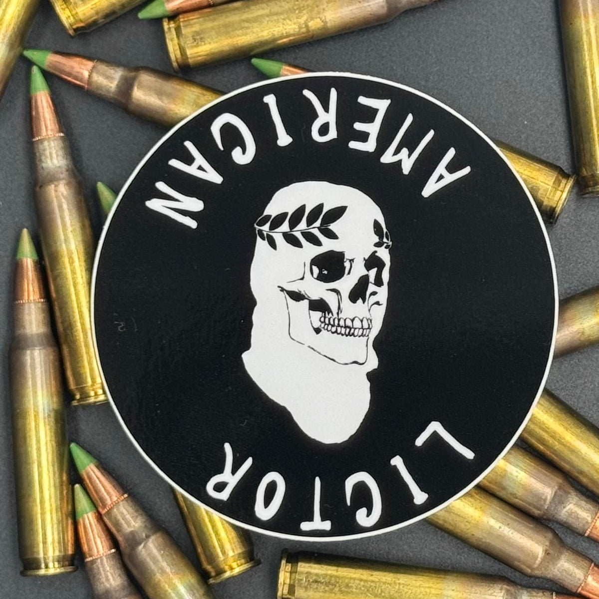 Sticker of the American Lictor Skull Logo in black on a bed of ammo