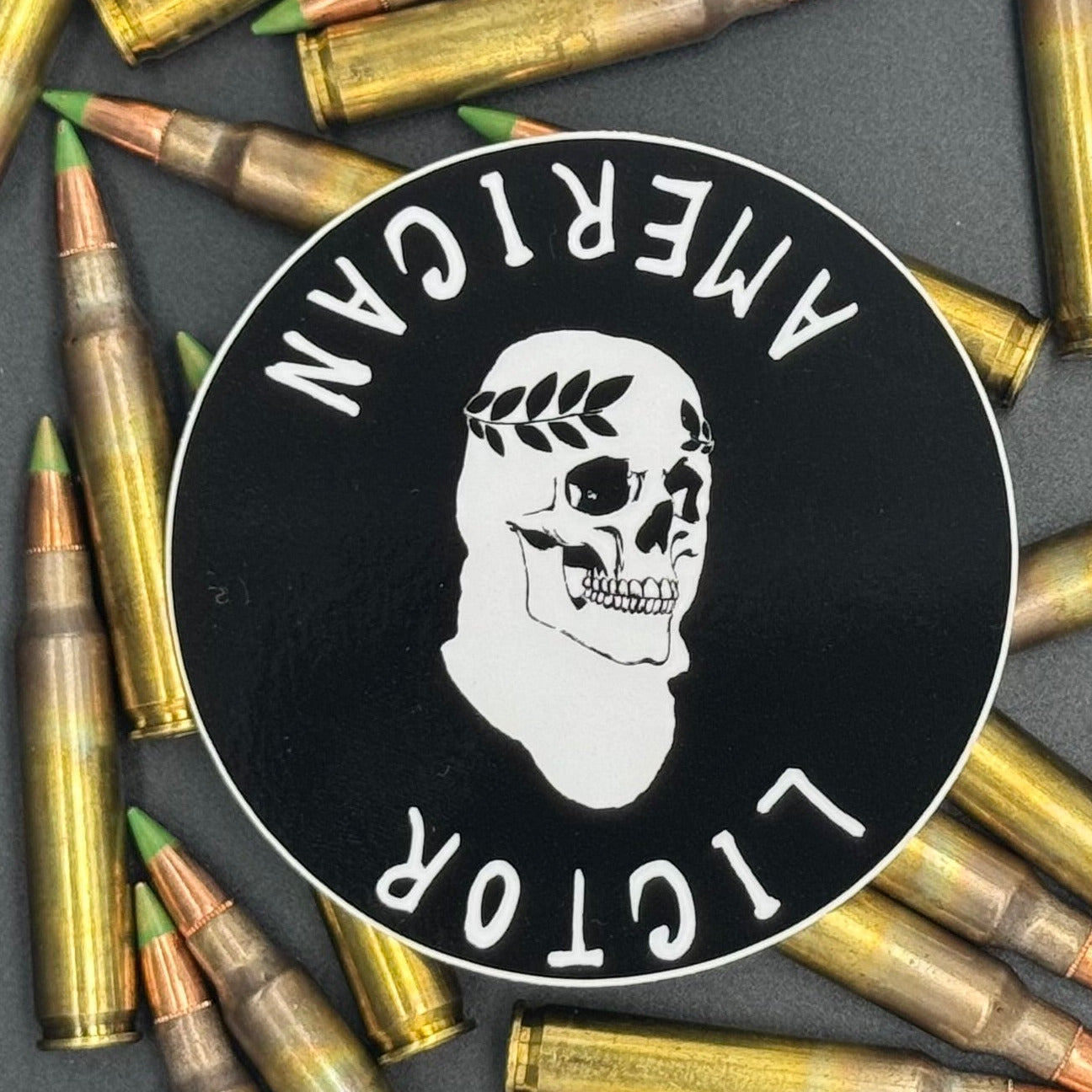 Sticker of the American Lictor Skull Logo in black on a bed of ammo