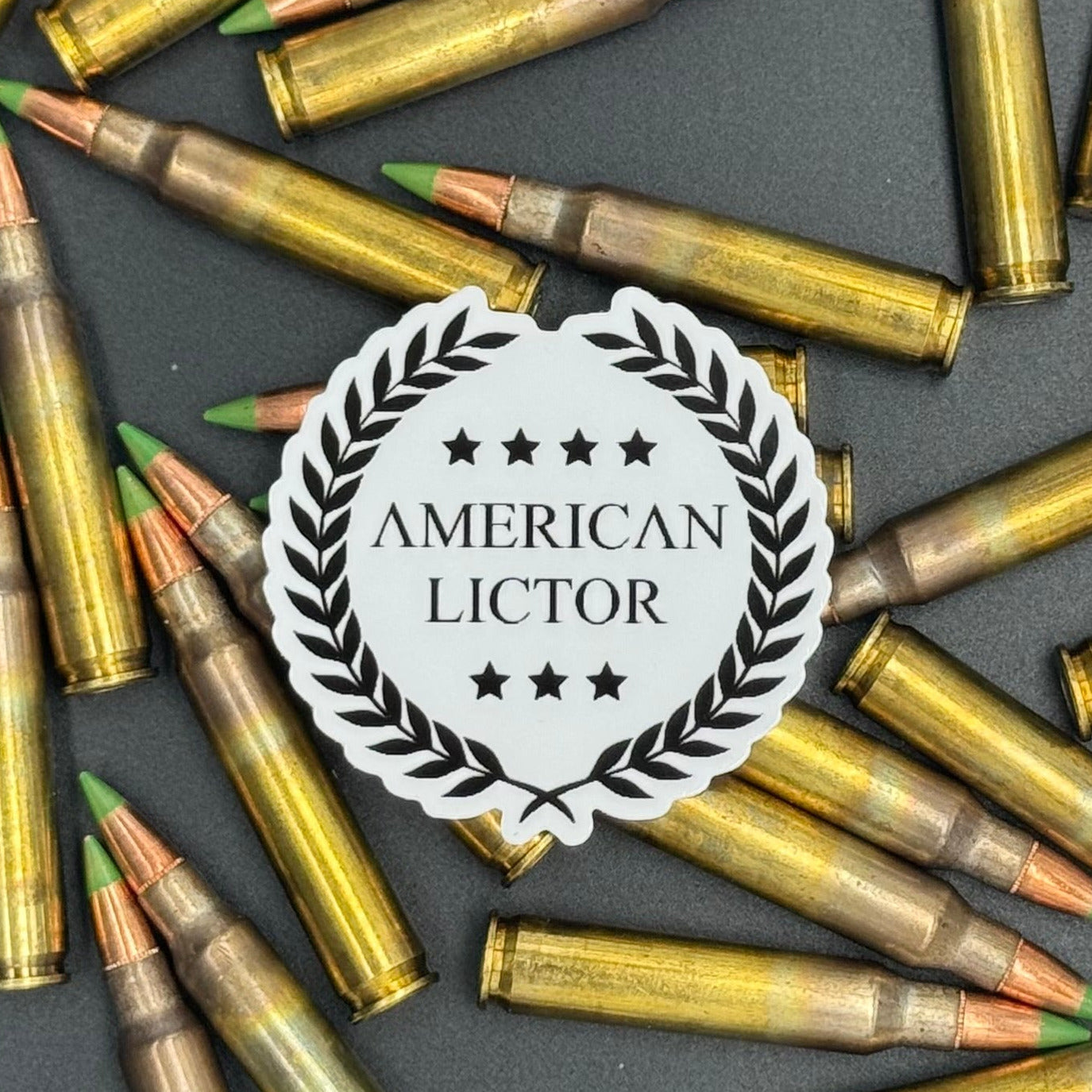 Sticker of the American Lictor Logo in white on a bed of ammo
