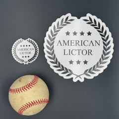 Sticker of an XL American Lictor Logo in white pictured with a baseball for scale
