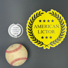 Sticker of an XL American Lictor Logo in yellow pictured with a baseball for scale