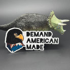 Sticker of an Eagle wearing a ski mask with the text 'Demand American Made' posing with a dinosaur