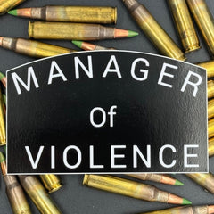 Black sticker with the text 'Manager of Violence' on a bed of ammo