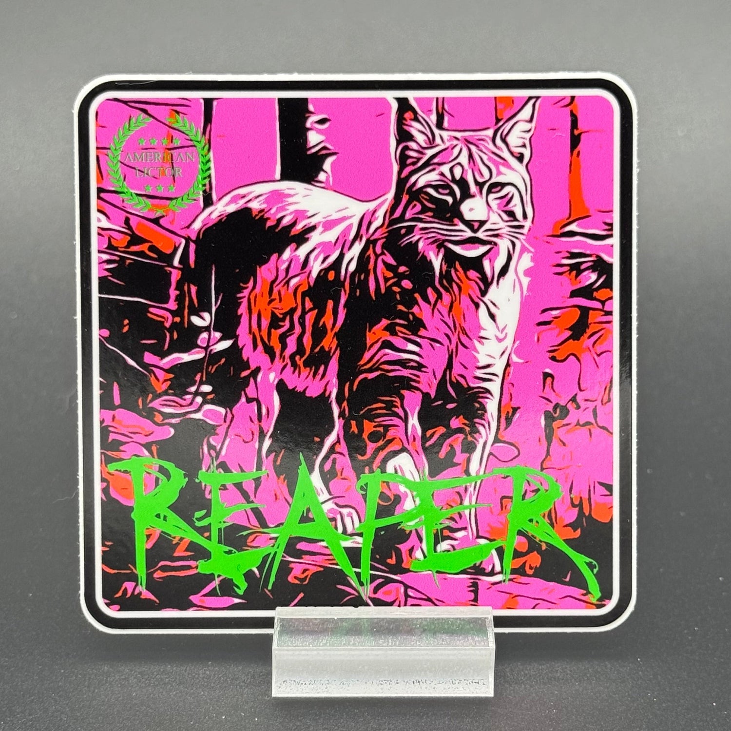 Black, green and pink sticker of a bobcat with the text 'Reaper'