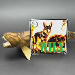 Multicolor sticker of a coyote with the text 'Wily' posed with a Dunklesteus