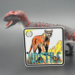 Multicolor sticker of a mountain lion with the text 'Hostile' posed with a dinosaur