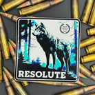 Black, blue and white Sticker of a wolf with the text ''Resolute on a bed of ammo