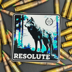 Black, blue and white Sticker of a wolf with the text ''Resolute on a bed of ammo